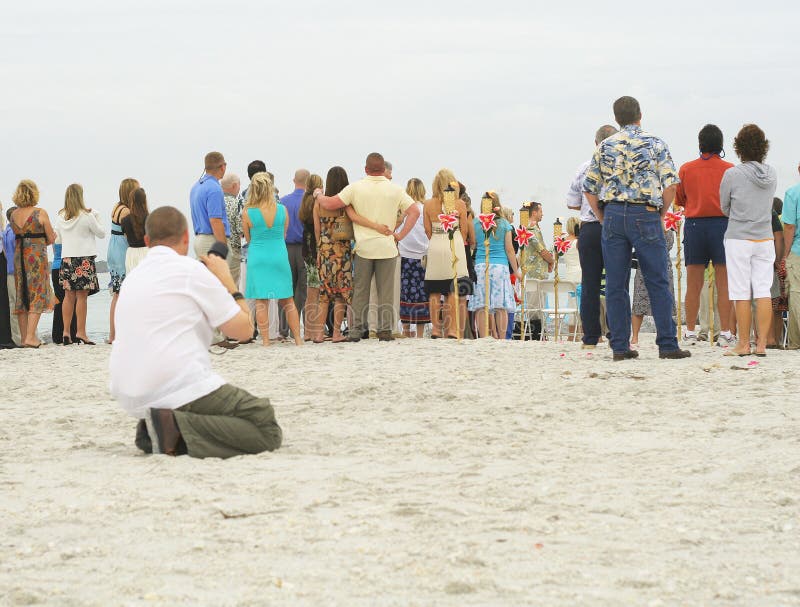 Photographer taking photos of group on beach