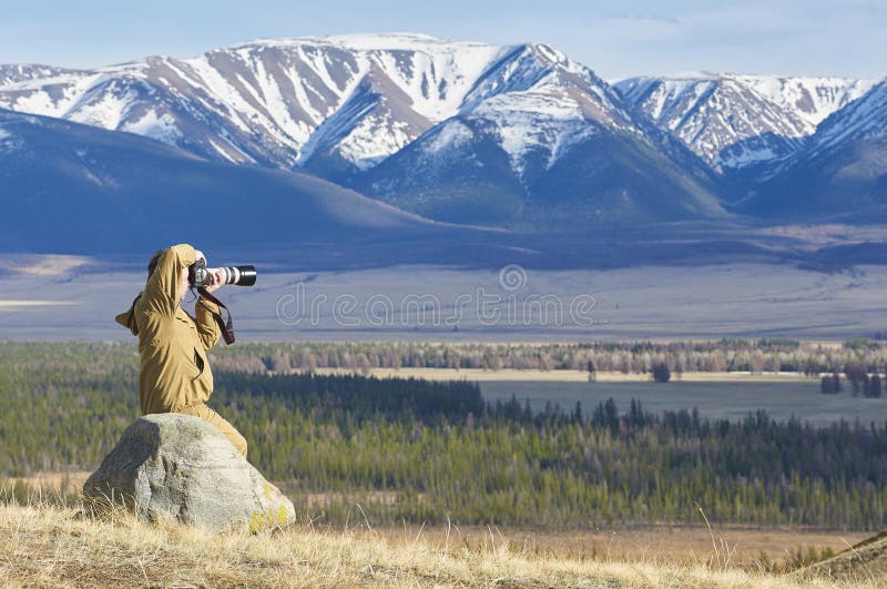 Photographer taking pictures of a mountain chain