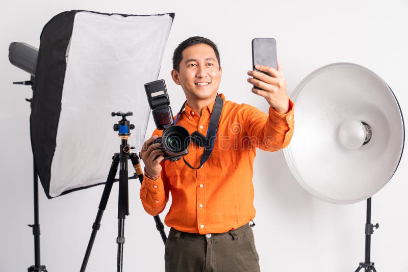 Photographer Taking Selfie while Holding Camera with Lighting Equipment