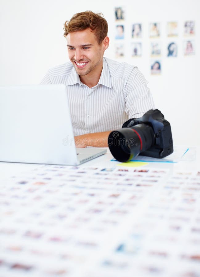 Photographer Using Laptop and Smiling. Smart Male Photographer Sitting