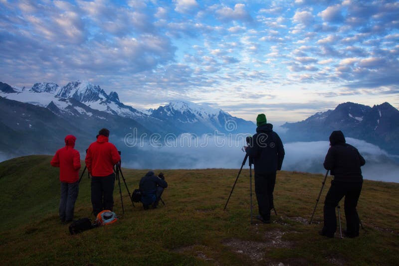 Photographers stay on lake and takes photos. Dreamy mountains, orange sunrise in a beautiful valley. Colorful summer. View of the Lac Blanc lake with Mont Blanc stock images Photographers stay on lake and takes photos. Dreamy mountains, orange sunrise in a beautiful valley. Colorful summer. View of the Lac Blanc lake with Mont Blanc stock images