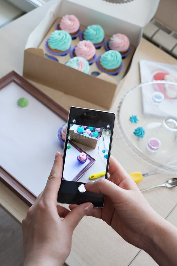 Photographie d'une boîte avec des petits gâteaux et d'un cadre en bois avec un téléphone image stock Photographie d'une boîte avec des petits gâteaux et d'un cadre en bois avec un téléphone image stock