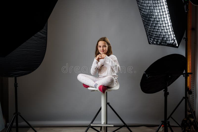Photographing children in professional photo studio with lighting equipment