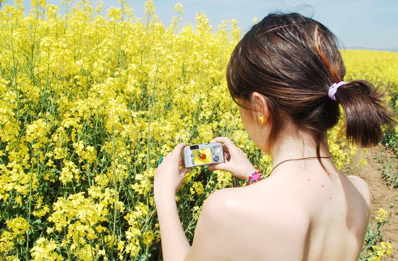 Girl taking photos of a ladybug on canola field. Capturing sunlight stock images, royalty-free photos and pictures