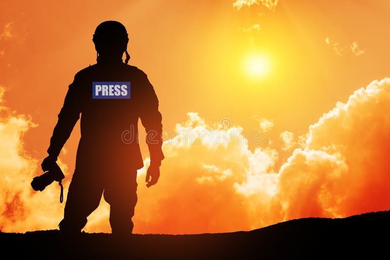 Photojournalist silhouette documenting war or conflict. Photojournalist at sunset.