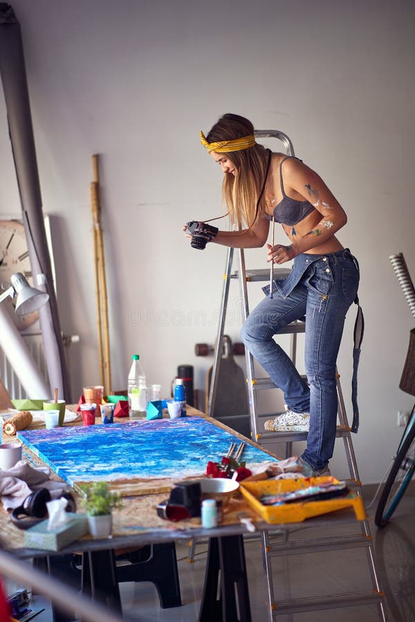 Photos of Art. Female Artist Using Camera in Art Studio Stock Photo