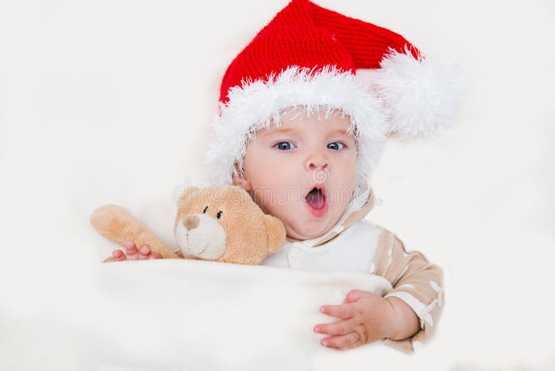 Photos de jeune bébé de sourire dans un chapeau de Santa Claus image libre de droits Photos de jeune bébé de sourire dans un chapeau de Santa Claus image libre de droits