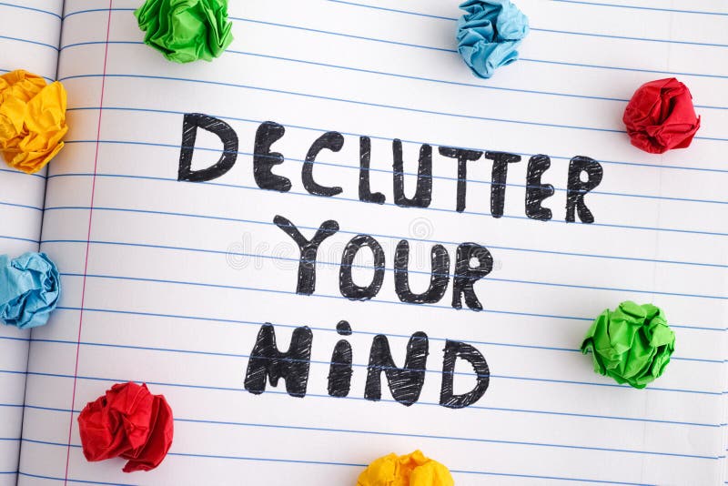 Phrase Declutter Your Mind on notebook sheet with colorful crumpled paper balls around it royalty free stock photo
