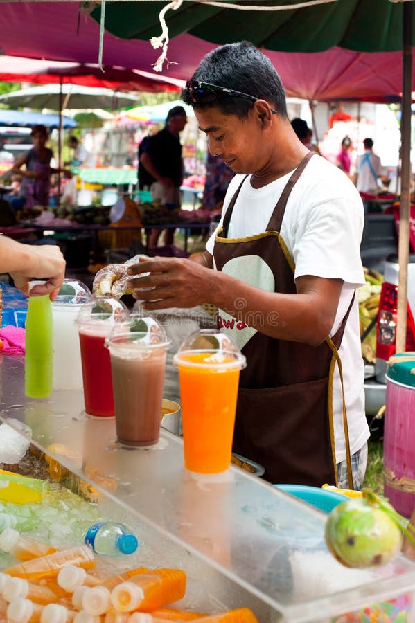 Thai man selling fresh juice at market