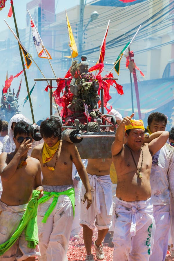 PHUKET - OCT 11: Devotees of a Chinese Taoist shrine carry a palanquin housing a Chinese God idol in a street procession to mark the Phuket Vegetarian Festival on Oct 11, 2013 in Phuket, Thailand. PHUKET - OCT 11: Devotees of a Chinese Taoist shrine carry a palanquin housing a Chinese God idol in a street procession to mark the Phuket Vegetarian Festival on Oct 11, 2013 in Phuket, Thailand.