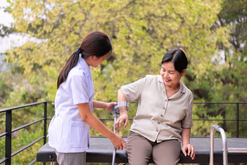 Physiotherapist Helping Senior Woman Hand Holding Crutch Trying To Walk Physical Therapy Concept