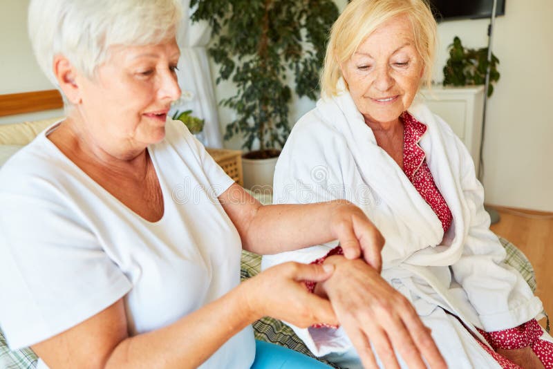 Physiotherapist doing acupressure on the hand of senior citizen at home or in nursing home. Physiotherapist doing acupressure on the hand of senior citizen at home or in nursing home