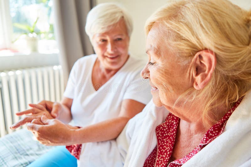 Physiotherapist massaging senior woman`s hand as acupressure at home or in nursing home. Physiotherapist massaging senior woman`s hand as acupressure at home or in nursing home