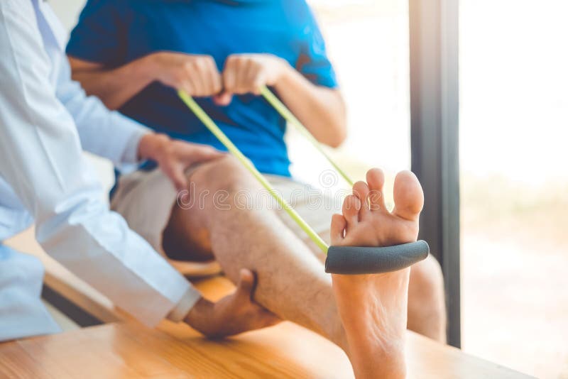 Physiotherapist mężczyzna daje oporu zespołu ćwiczenia traktowaniu O kolanie atlety Fizycznej terapii męski cierpliwy pojęcie
