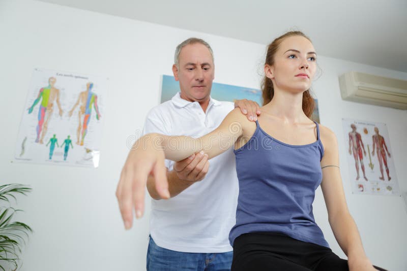 Physiotherapist z ręka żeńskim pacjentem w pokoju fotografia royalty free Physiotherapist z ręka żeńskim pacjentem w pokoju fotografia royalty free