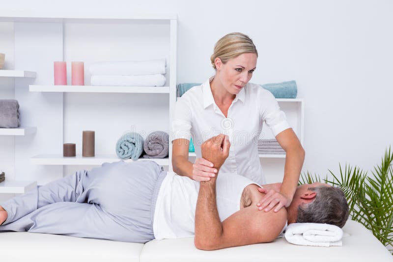 Physiothérapeute faisant le massage d'épaule à son patient image libre de droits Physiothérapeute faisant le massage d'épaule à son patient image libre de droits