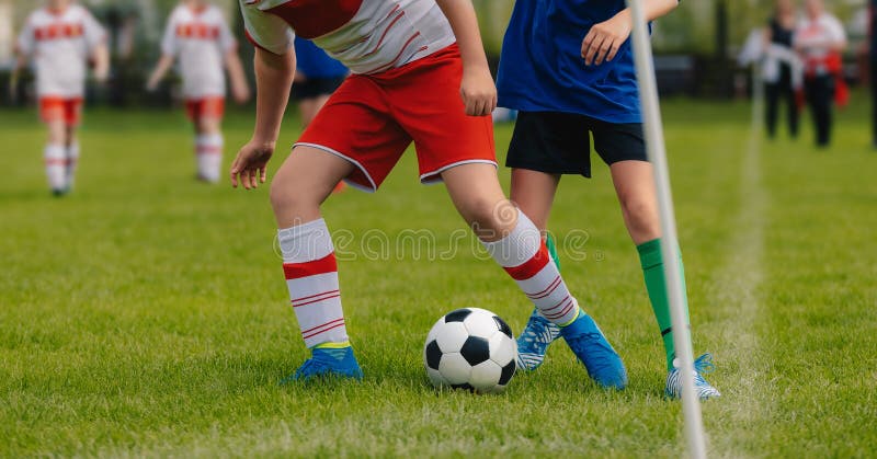 Soccer Duel. Running Soccer Football Players. Footballers Kicking Football Match. Soccer School Tournament. Young Soccer Players Running After the Ball. Soccer Stadium in the Background