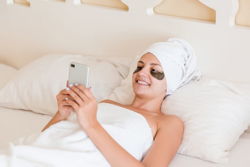 Pi?kna m?oda kobieta z poni?szymi oko ?atami i u?ywa? telefon kom zdjęcia stock Pi?kna m?oda kobieta z poni?szymi oko ?atami i u?ywa? telefon kom zdjęcia stock