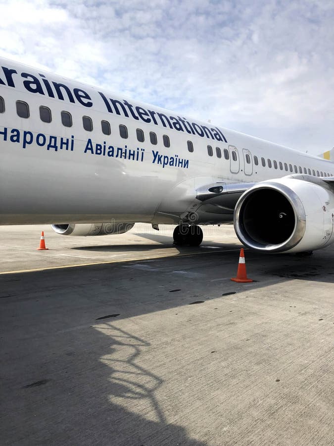 Pi?kny szybki bia?y d?etowy samolot Ukraina linie lotnicze z silnikiem i skrzyd?ami na pasie startowym przy lotniskiem Ukraina, K zdjęcie stock Pi?kny szybki bia?y d?etowy samolot Ukraina linie lotnicze z silnikiem i skrzyd?ami na pasie startowym przy lotniskiem Ukraina, K zdjęcie stock