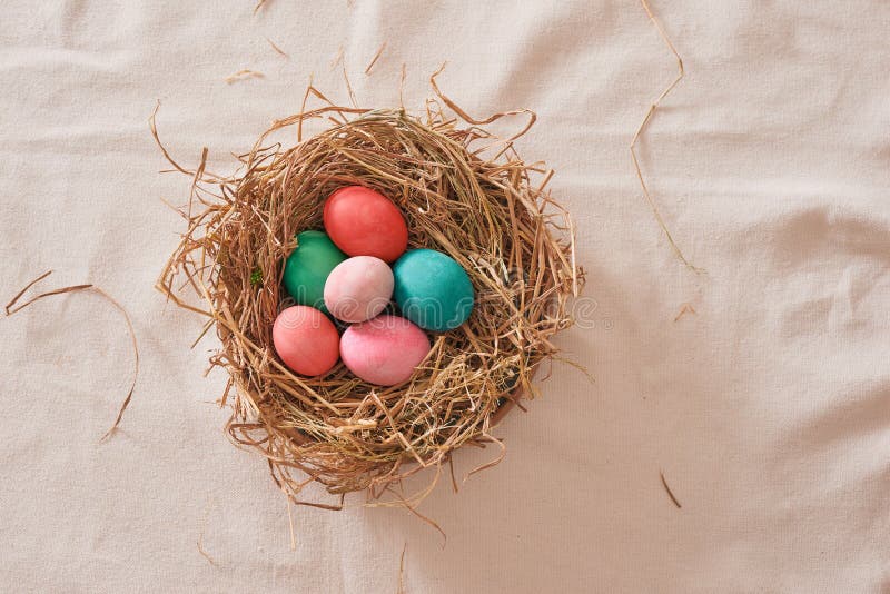 Beautiful Easter multi color egg in straw on wooden background, Easter day concept. Beautiful Easter multi color egg in straw on wooden background, Easter day concept.