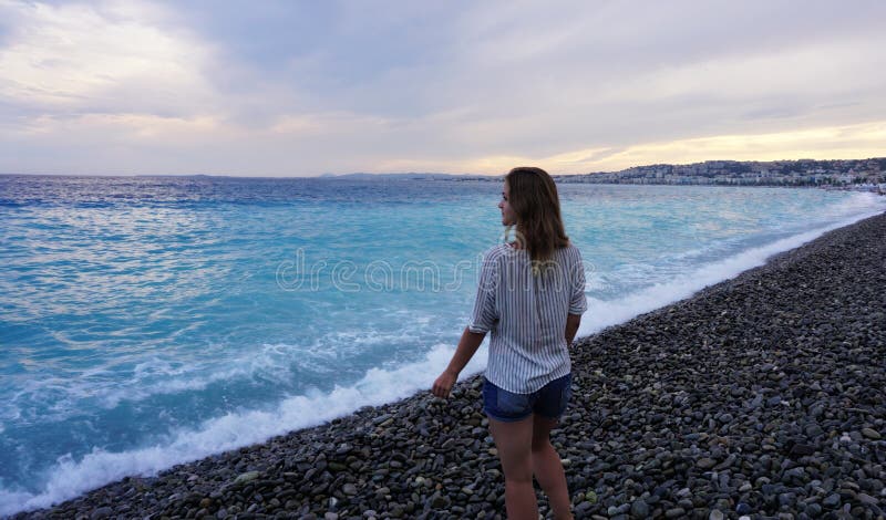 Piacevole, Francia Giovane donna che gode della costa azzurrata e che esamina il mare immagine stock Piacevole, Francia Giovane donna che gode della costa azzurrata e che esamina il mare immagine stock