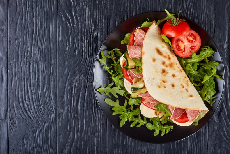 Piadina italiano con la mozzarella, pomodoro, salame immagine stock libera da diritti Piadina italiano con la mozzarella, pomodoro, salame immagine stock libera da diritti