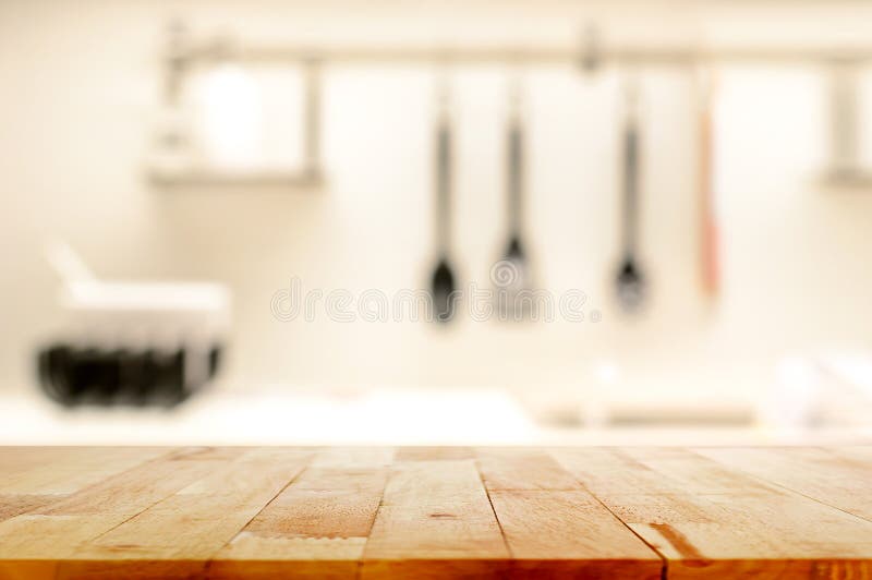 Piano d'appoggio di legno (come isola di cucina) sul fondo della cucina della sfuocatura immagine stock Piano d'appoggio di legno (come isola di cucina) sul fondo della cucina della sfuocatura immagine stock
