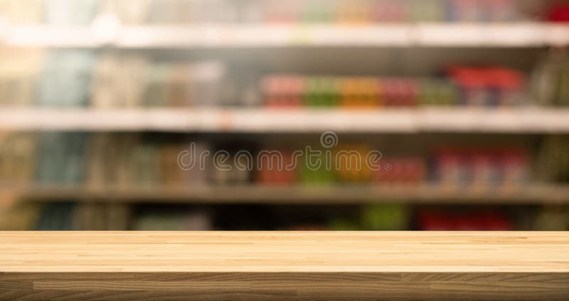 Piano d'appoggio di legno su sfuocatura del fondo dello scaffale del prodotto del supermercato