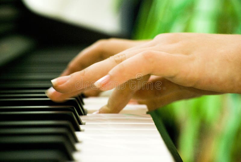 Un primo piano di un paio di mani suonando un pianoforte.