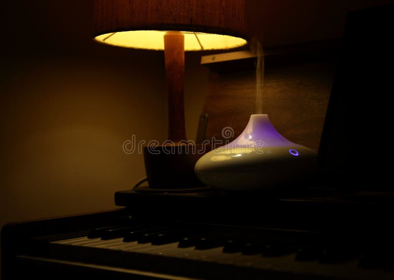 Pianotoetsenbord, schemerlamp, etherische oliespuitbus royalty-vrije stock foto's Pianotoetsenbord, schemerlamp, etherische oliespuitbus royalty-vrije stock foto's