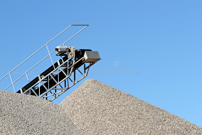 Conveyor over heaps of gravel at an industrial cement plant. Conveyor over heaps of gravel at an industrial cement plant