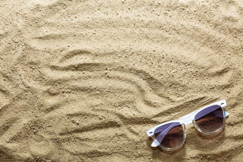 Piaskowata plaża i okulary przeciwsłoneczni na seashore lub oceanie beach tło Pojęcie: wakacje morze, podróż, wakacje zdjęcie stock Piaskowata plaża i okulary przeciwsłoneczni na seashore lub oceanie beach tło Pojęcie: wakacje morze, podróż, wakacje zdjęcie stock