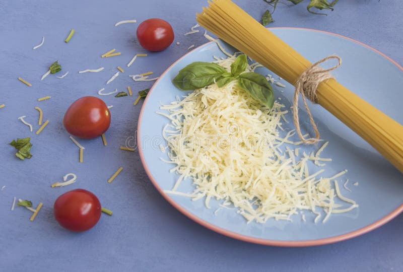 Plate with spaghetti and grated cheese with basil leaves. immagine stock