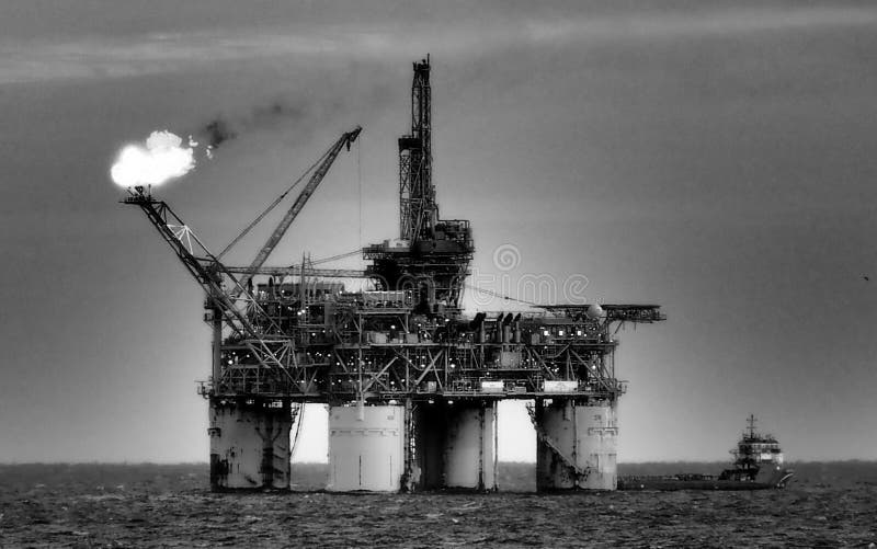 Piattaforma petrolifera o impianto di perforazione scintillante in mare fotografie stock libere da diritti Piattaforma petrolifera o impianto di perforazione scintillante in mare fotografie stock libere da diritti
