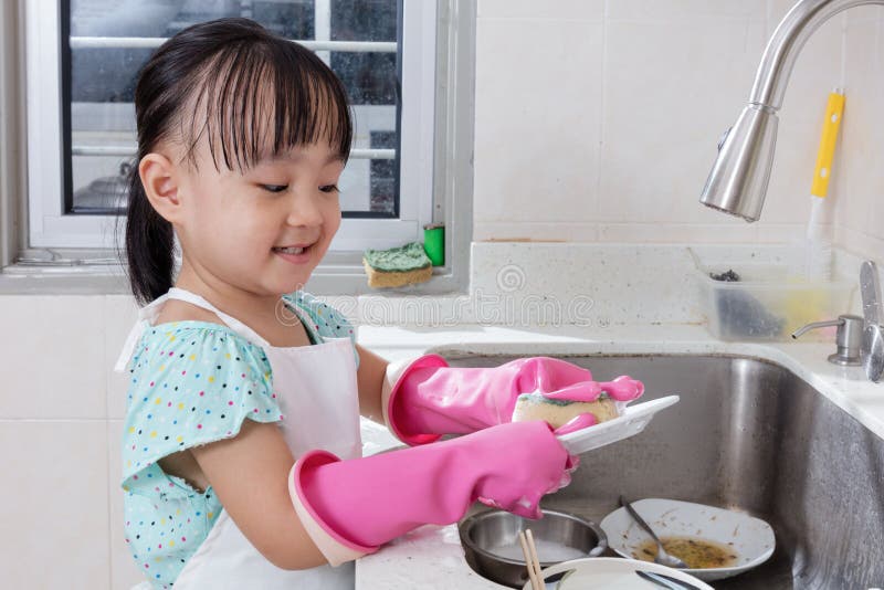 Piatti cinesi asiatici di lavaggio della bambina nella cucina