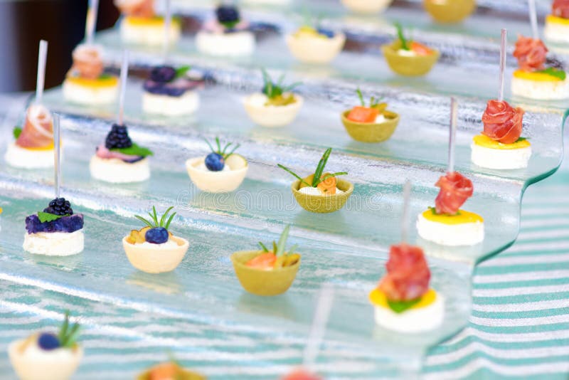 Piatti con gli spuntini assortiti del cibo da mangiare con le mani su un partito o su una cena di evento fotografia stock Piatti con gli spuntini assortiti del cibo da mangiare con le mani su un partito o su una cena di evento fotografia stock