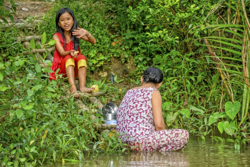 Piatti di lavaggio della donna nel Mekong fotografia stock Piatti di lavaggio della donna nel Mekong fotografia stock