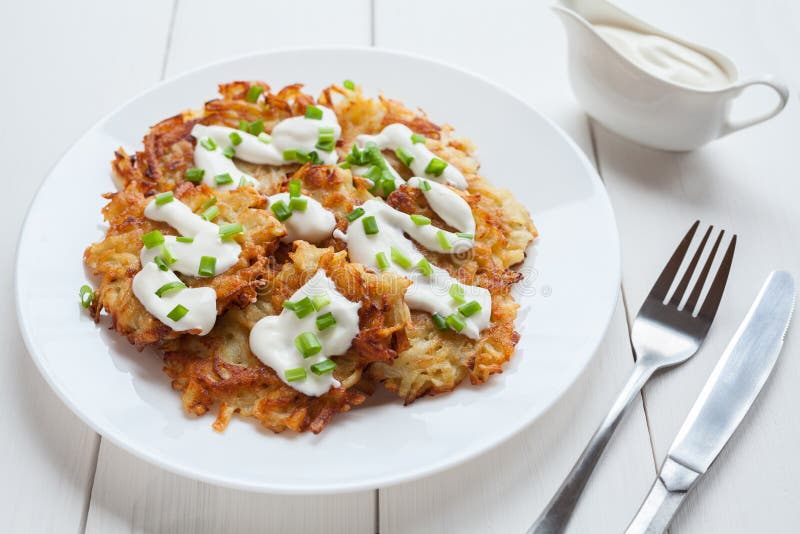 Piatto bianco dei pancake di patata o del latke fotografie stock Piatto bianco dei pancake di patata o del latke fotografie stock