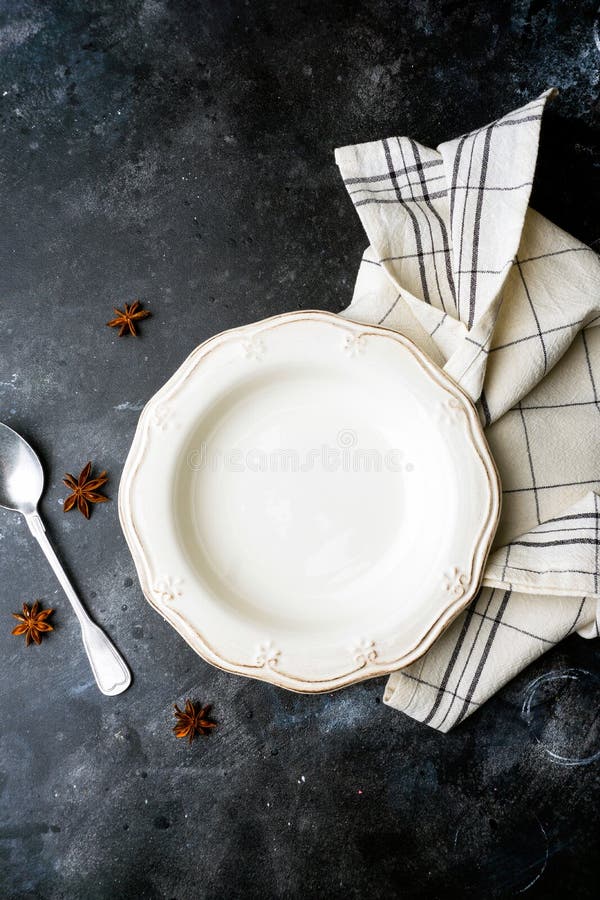 Piatto bianco vuoto su un fondo scuro con un cucchiaio, decorato con un mazzo di lavanda e di un tovagliolo Concetto d'annata dom immagine stock Piatto bianco vuoto su un fondo scuro con un cucchiaio, decorato con un mazzo di lavanda e di un tovagliolo Concetto d'annata dom immagine stock