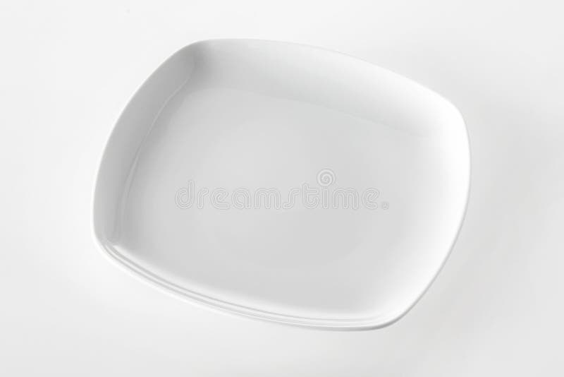 Empty plain white rectangular plate for serving dinner with copyspace for your food or product placement over a white background, high angle view. Empty plain white rectangular plate for serving dinner with copyspace for your food or product placement over a white background, high angle view