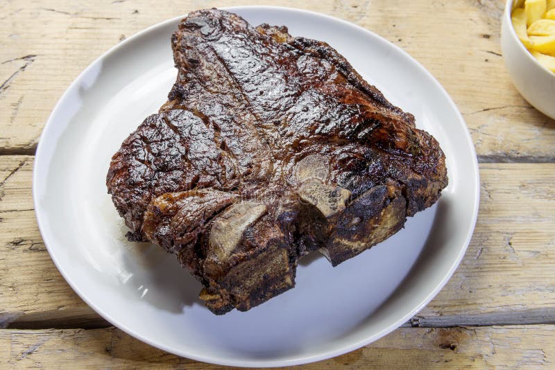 Piatto rotondo con la bistecca di manzo arrostita della lombata immagine stock libera da diritti Piatto rotondo con la bistecca di manzo arrostita della lombata immagine stock libera da diritti