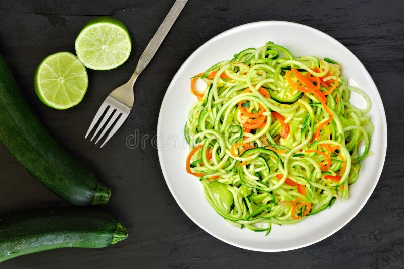 Piatto sano della tagliatella dello zucchini con le carote e la calce fotografia stock libera da diritti Piatto sano della tagliatella dello zucchini con le carote e la calce fotografia stock libera da diritti