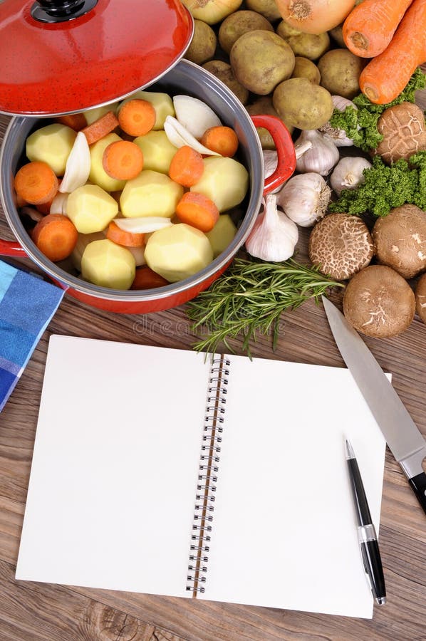 Piatto vegetali della casseruola con il libro di cucina, spazio della copia, verticale fotografie stock Piatto vegetali della casseruola con il libro di cucina, spazio della copia, verticale fotografie stock