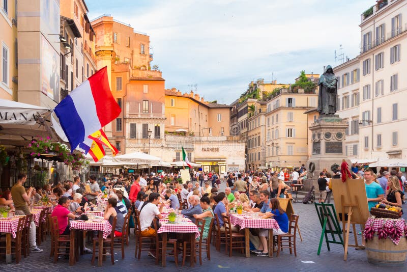 Piazza Campo De Fiori in Rome, Italy. ROME, ITALY - JUNE 13 2014: People having aperitif which in Italy traditionally includes free all you can eat buffet of stock photography Piazza Campo De Fiori in Rome, Italy. ROME, ITALY - JUNE 13 2014: People having aperitif which in Italy traditionally includes free all you can eat buffet of stock photography