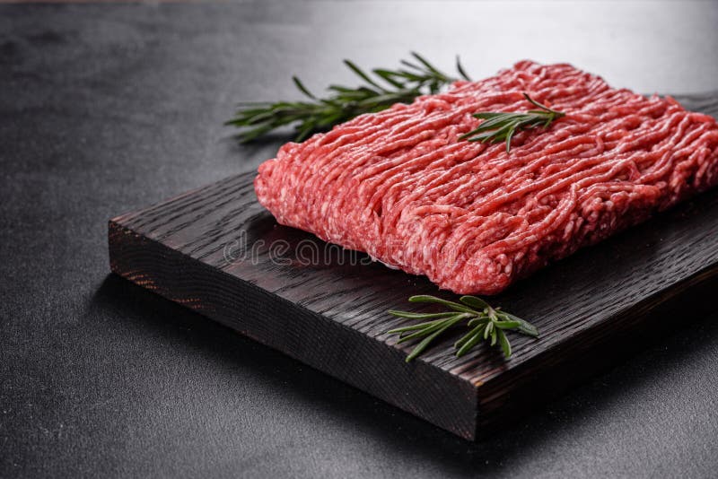 Picante de carne fresca cruda en un fondo oscuro. preparación de cocción de chuletas