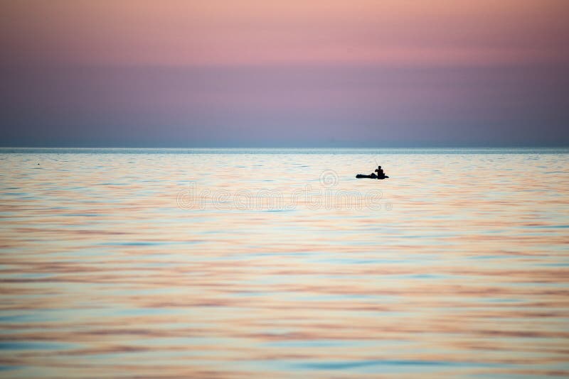 Piccola barca nel mare ad alba fotografia stock Piccola barca nel mare ad alba fotografia stock
