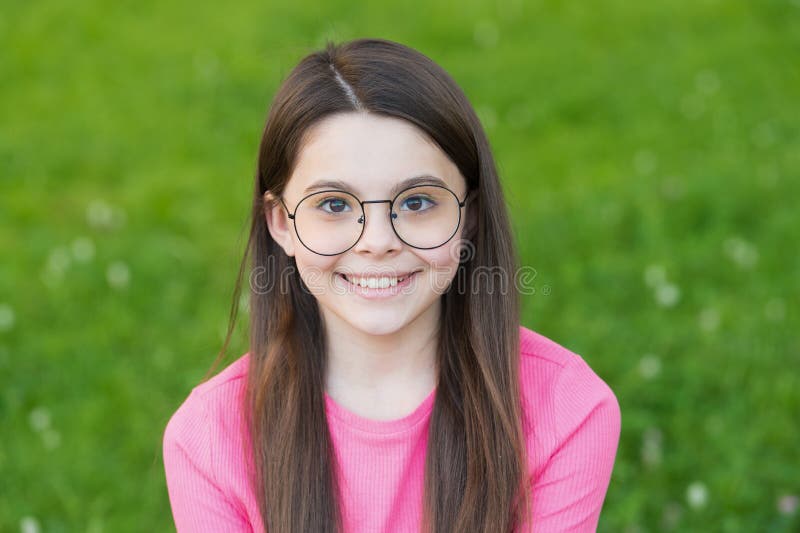 Piccola bellezza con un sorriso felice. bambino seduto sull'erba verde. bambino si rilassi all'aperto d'estate. moda fotografia stock libera da diritti