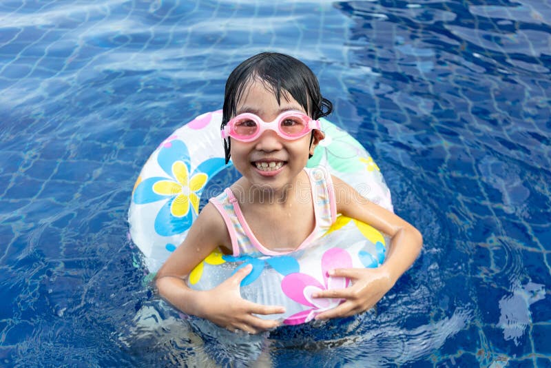 Piccola ragazza cinese asiatica che gioca nella piscina