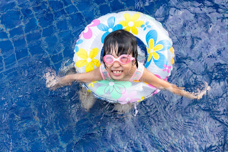 Piccola ragazza cinese asiatica che gioca nella piscina