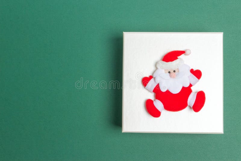 Piccola Santa Claus su un contenitore di regalo di giorno di Natale fotografia stock Piccola Santa Claus su un contenitore di regalo di giorno di Natale fotografia stock